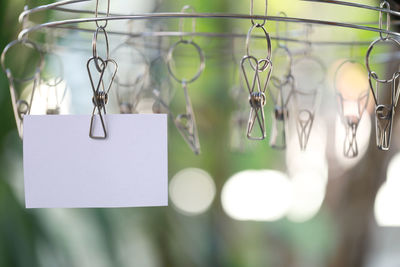 Close-up of blank paper hanging on clothesline