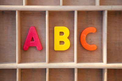 Close-up of colorful abc alphabets in wooden shelf