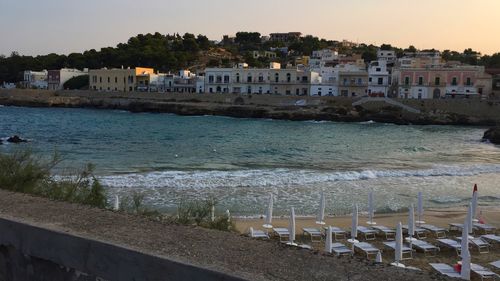 Houses by sea against clear sky