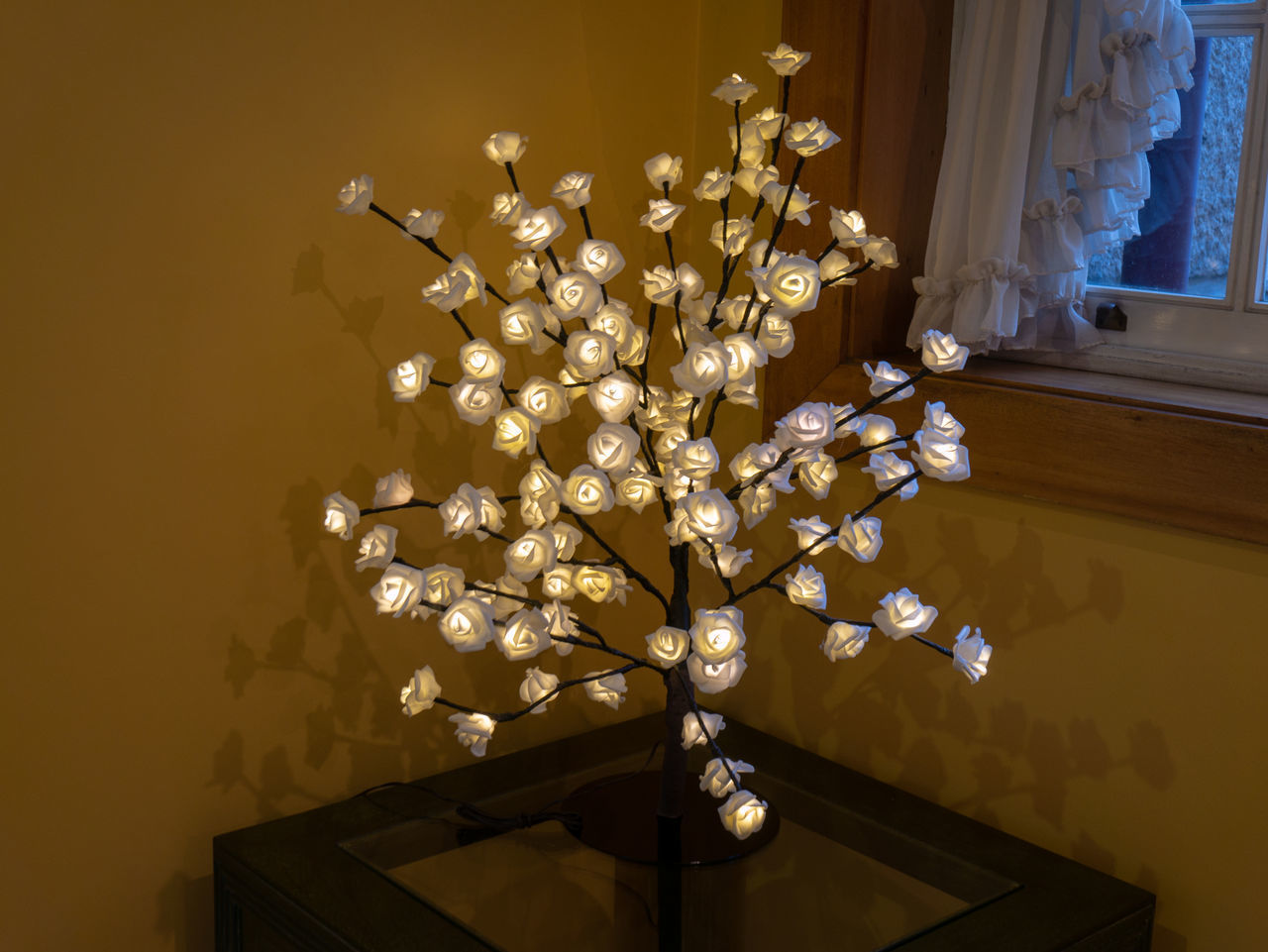 CLOSE-UP OF ILLUMINATED CHANDELIER HANGING ON TABLE