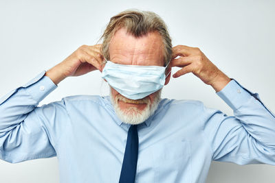 Senior man wearing mask against white background