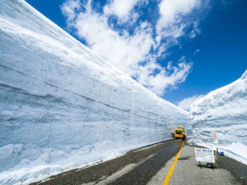 Road amidst snowcapped mountains against sky