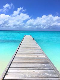 Pier over sea against blue sky