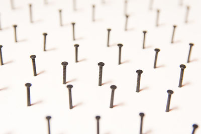 Full frame shot of nails in white table