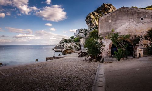 Built structure by sea against sky