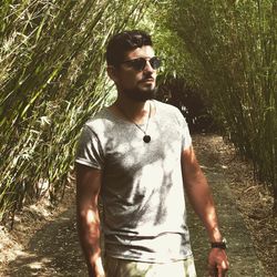 Young man wearing sunglasses while standing on land