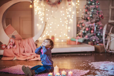 Full length of girl in illuminated christmas tree