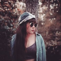 Portrait of young woman wearing sunglasses standing outdoors