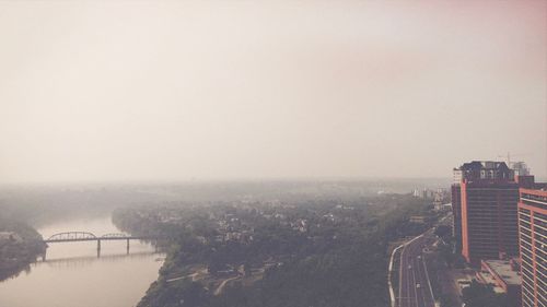 High angle view of buildings by river against sky