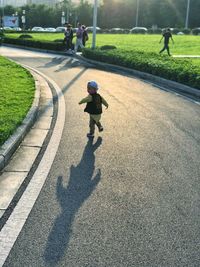 Rear view of boy on road