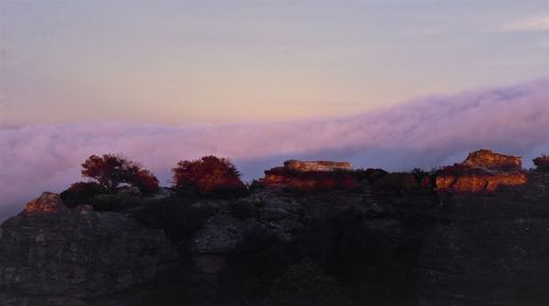 Rock formations on landscape against sky during sunset