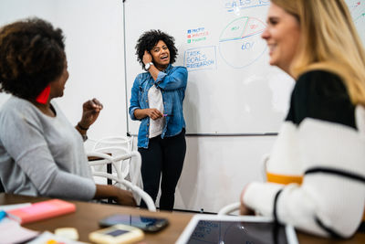 Businesswoman giving presentation to colleagues in office