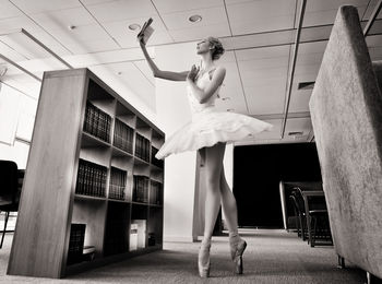 A charming ballerina went to the library to choose a new book during a break