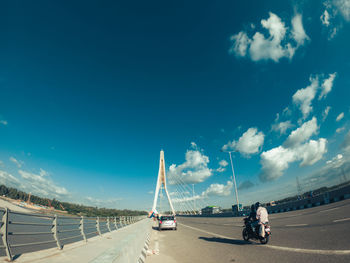 Vehicles on road against blue sky