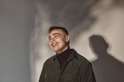 Cheerful man looking away over white background in studio