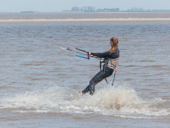 Full length of woman surfing on sea