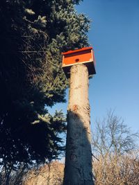 Low angle view of birdhouse on tree against sky