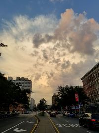 View of city street against cloudy sky