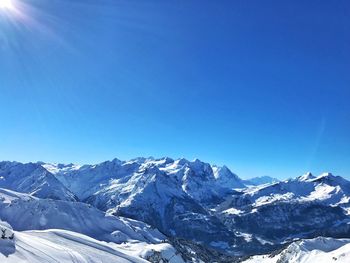 Scenic view of snowcapped mountains against clear blue sky