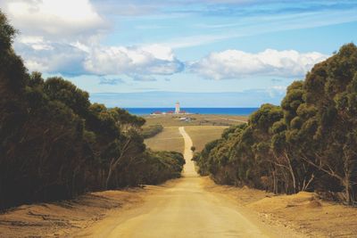 Scenic view of road by sea against sky