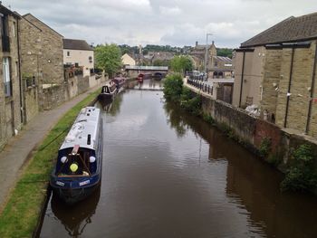 Canal amidst buildings in city against sky