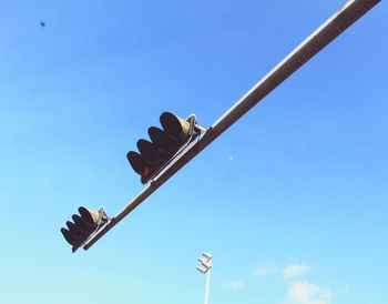 Low angle view of arrow sign against clear blue sky