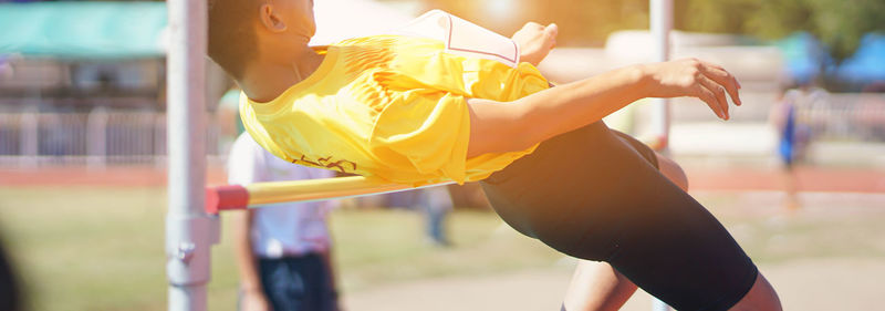 Midsection of woman holding yellow umbrella