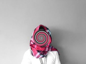 Close-up of man wearing hat against white background
