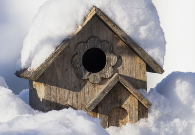 A bird house covered in snow