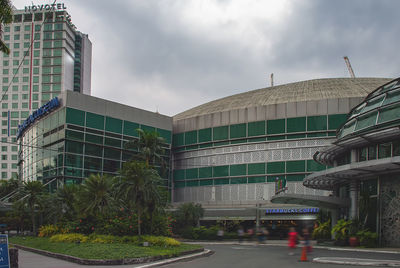 People in modern building against sky