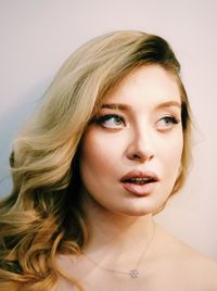 Close-up portrait of young woman against white background