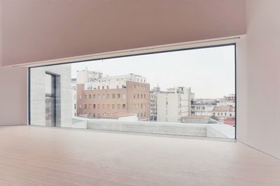 Buildings against clear sky seen through glass window