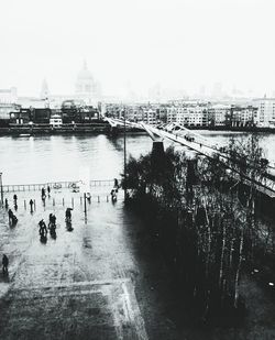 Bridge over river in city against sky