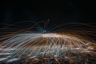 Person spinning wire wool at night