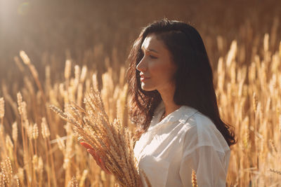 Young woman looking away in field