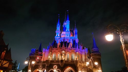 Low angle view of illuminated buildings against sky at night