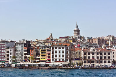 Buildings in city against clear sky