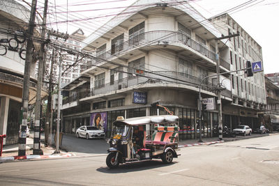 People on street amidst buildings in city