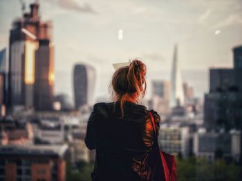 Rear view of woman looking at city buildings