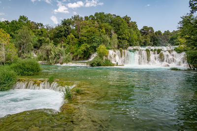 Scenic view of waterfall against sky