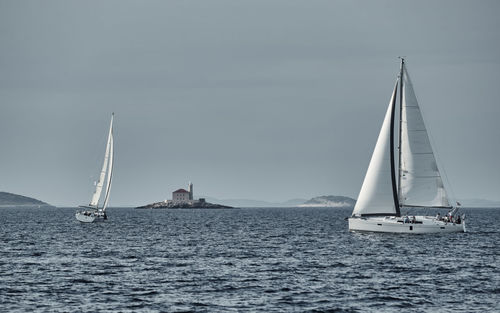 Sailboat sailing on sea against sky