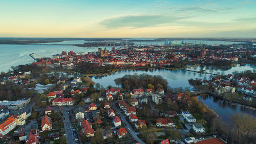 High angle view of townscape by sea against sky