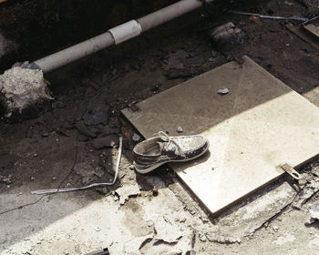 High angle view of shoe on manhole at street