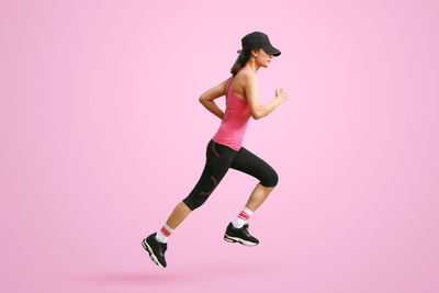Rear view of woman exercising against white background