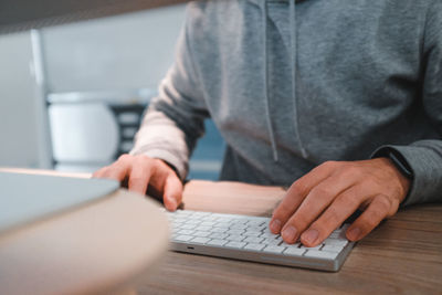 Midsection of man using laptop on table