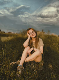 Portrait of woman sitting on field