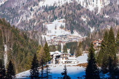 Winter in sauris di sotto. traditional architecture under the sun and snow