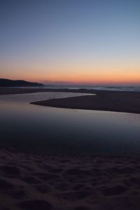 Scenic view of beach against sky during sunset