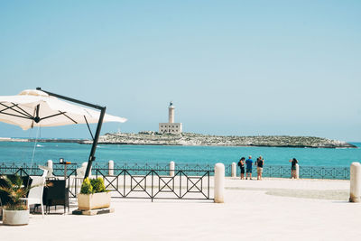 People on beach against clear sky