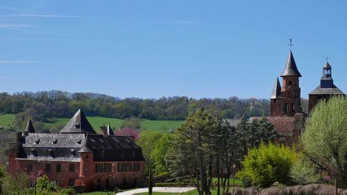 Houses by trees against sky